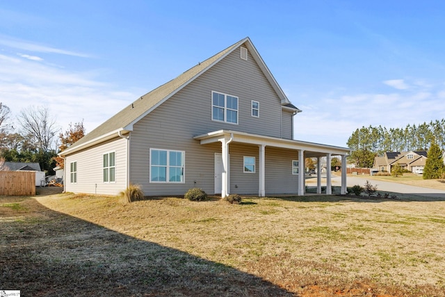 back of property featuring a porch and a yard