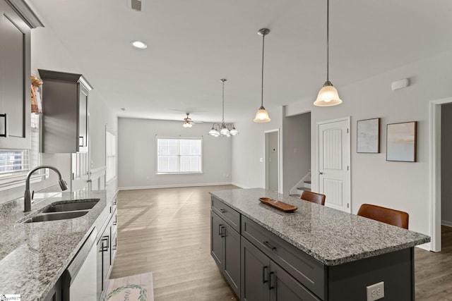 kitchen with dishwasher, a kitchen island, a healthy amount of sunlight, and sink