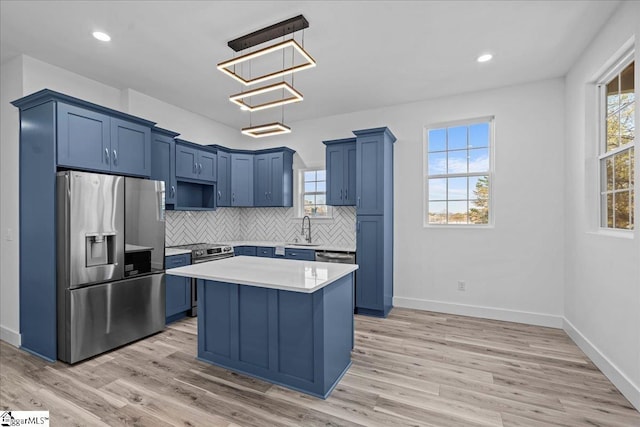 kitchen featuring stainless steel fridge, a kitchen island, hanging light fixtures, and light hardwood / wood-style flooring