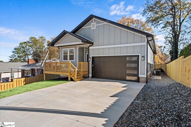 view of front of house featuring a front yard, central AC, and a garage