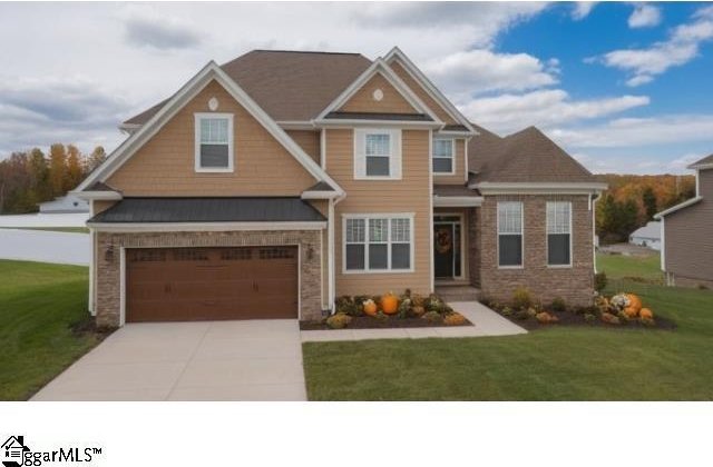 craftsman inspired home with a garage and a front yard