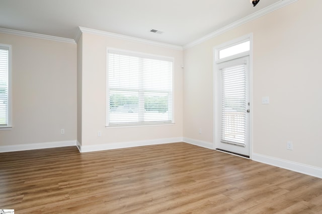 spare room with light wood-type flooring and ornamental molding