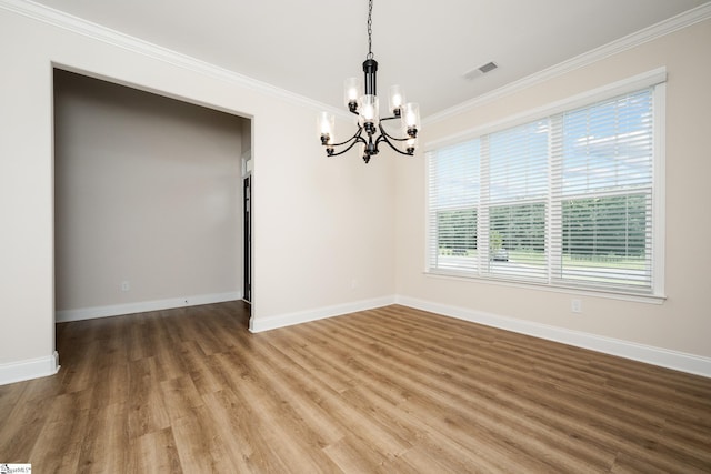 unfurnished room with ornamental molding, wood-type flooring, and a chandelier