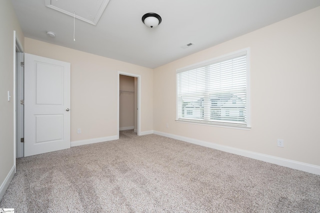 unfurnished bedroom with light carpet and a closet