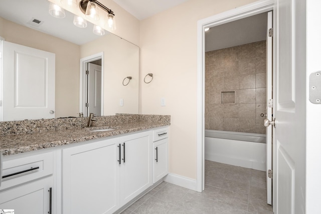 bathroom featuring tiled shower / bath combo, vanity, and tile patterned floors