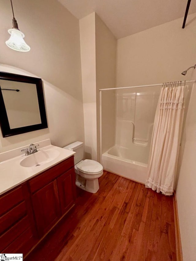 full bathroom with shower / tub combo, vanity, hardwood / wood-style flooring, and toilet