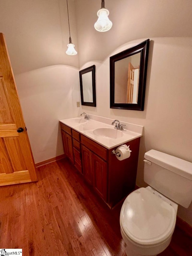 bathroom with hardwood / wood-style floors, vanity, and toilet