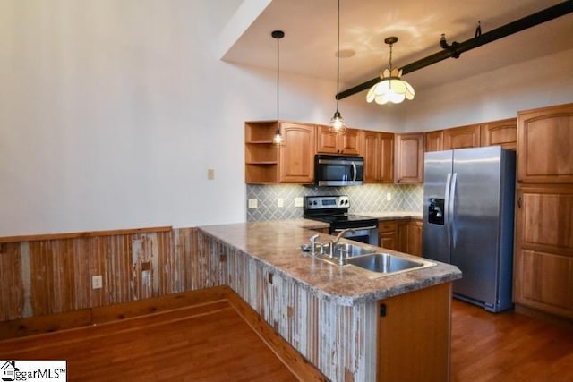 kitchen featuring sink, hanging light fixtures, stainless steel appliances, dark hardwood / wood-style flooring, and kitchen peninsula