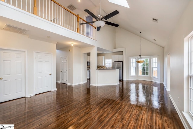 unfurnished living room with ceiling fan, dark hardwood / wood-style flooring, and high vaulted ceiling