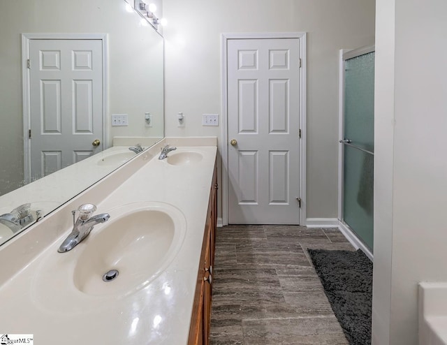 bathroom with vanity, a shower with shower door, and wood-type flooring