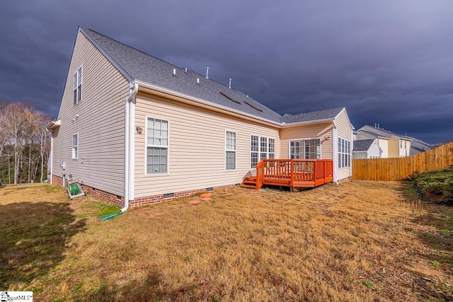 back of house with a deck and a yard