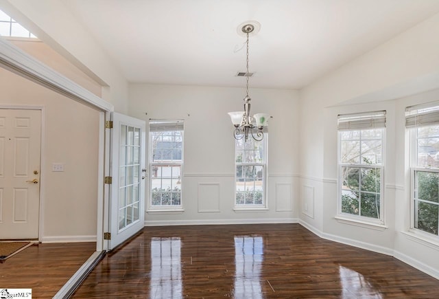 unfurnished dining area featuring dark hardwood / wood-style flooring and a notable chandelier