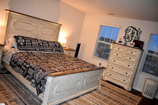 bedroom with hardwood / wood-style floors and lofted ceiling