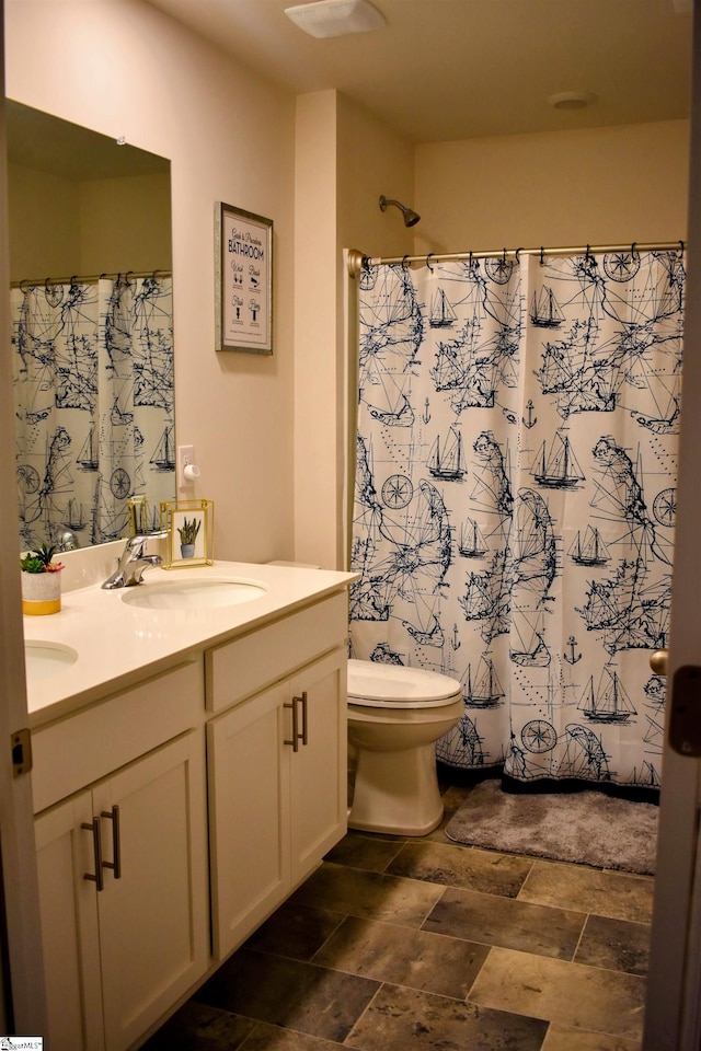 bathroom featuring vanity, toilet, and walk in shower