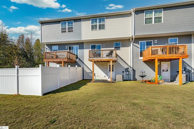 back of property with a wooden deck, central air condition unit, and a lawn