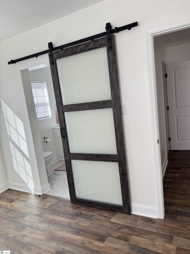 foyer featuring a barn door and dark wood-type flooring