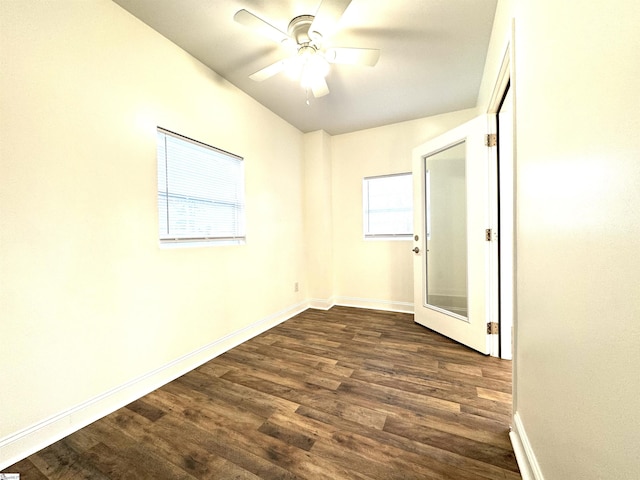 empty room with dark wood-type flooring, ceiling fan, and plenty of natural light