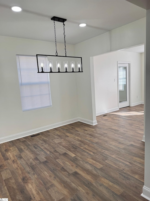 unfurnished dining area featuring dark wood-type flooring