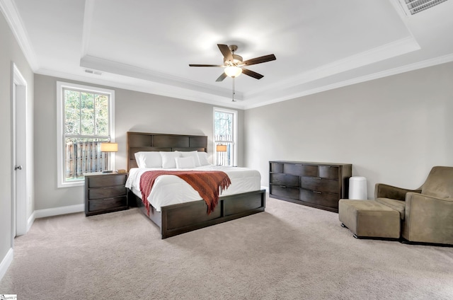 bedroom with light carpet, a tray ceiling, ceiling fan, and crown molding