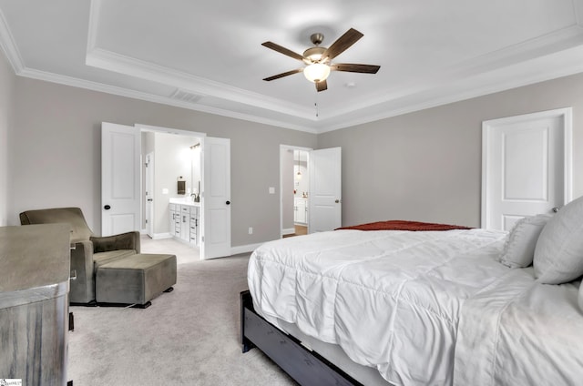 carpeted bedroom with a tray ceiling, ceiling fan, crown molding, and ensuite bathroom