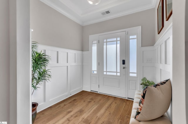 entryway with light wood-type flooring and crown molding