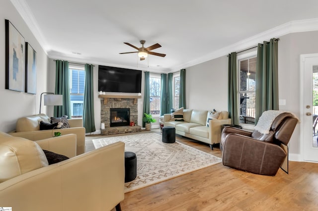 living room with ceiling fan, a fireplace, light hardwood / wood-style floors, and ornamental molding