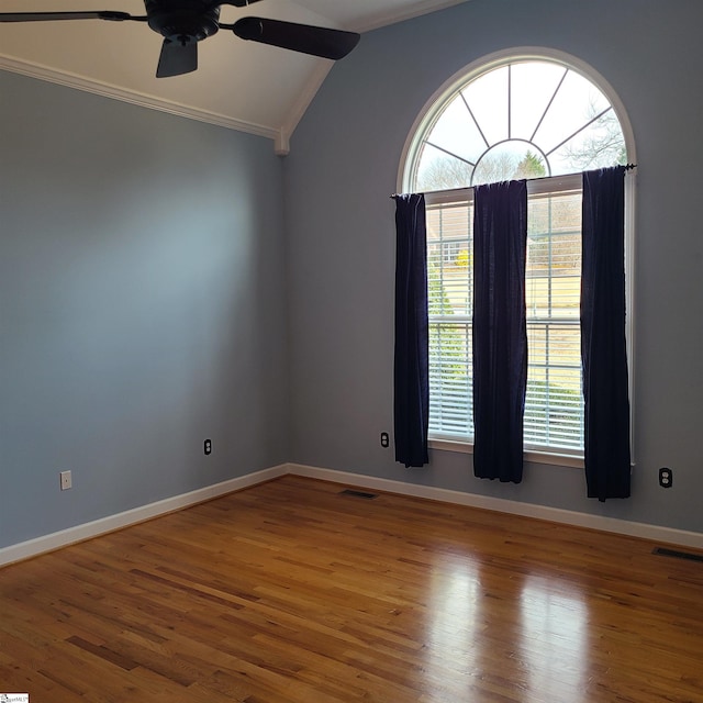 unfurnished room with ceiling fan, hardwood / wood-style floors, lofted ceiling, and ornamental molding