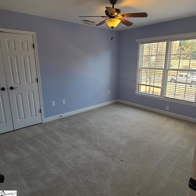 unfurnished room featuring ceiling fan and carpet