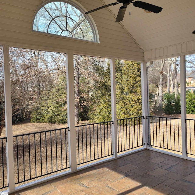 unfurnished sunroom featuring ceiling fan and vaulted ceiling