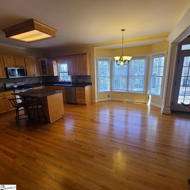 kitchen with dark hardwood / wood-style flooring, stainless steel appliances, and tasteful backsplash