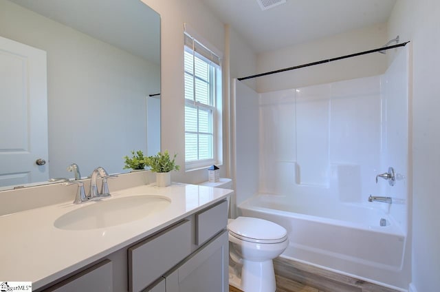 full bathroom featuring hardwood / wood-style floors, vanity, toilet, and bathtub / shower combination