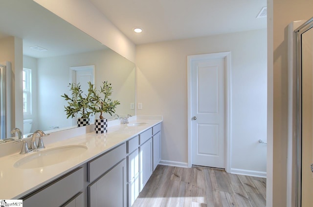 bathroom with hardwood / wood-style flooring, vanity, and toilet