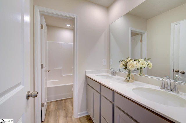 bathroom featuring hardwood / wood-style floors, vanity, and shower / tub combination