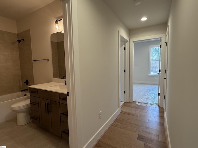 corridor with light hardwood / wood-style floors and sink