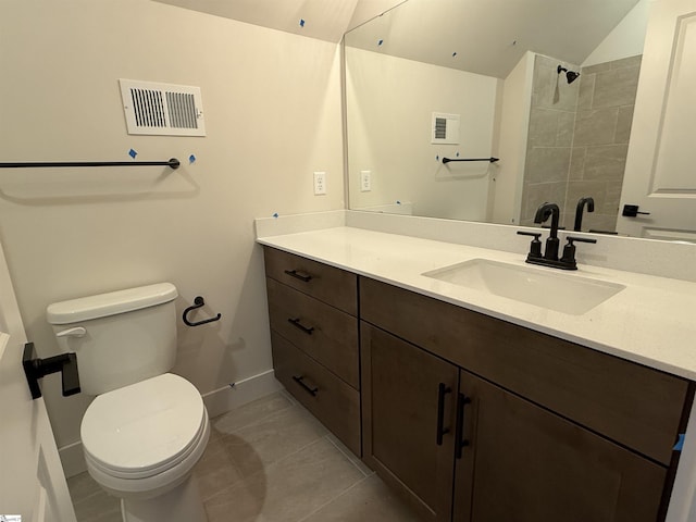 bathroom featuring tile patterned flooring, vanity, toilet, and vaulted ceiling