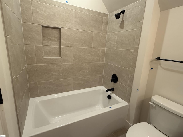 bathroom featuring tiled shower / bath combo and toilet