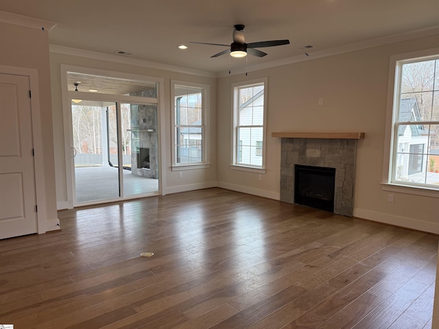 unfurnished living room with hardwood / wood-style flooring, a stone fireplace, and a wealth of natural light