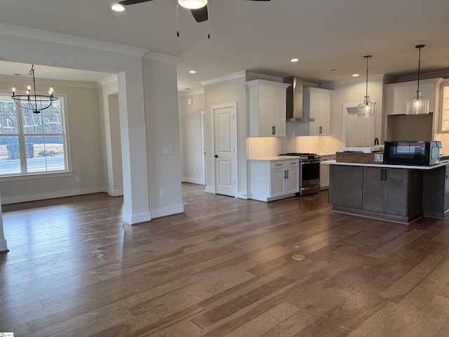 kitchen featuring wall chimney exhaust hood, dark wood-type flooring, white cabinets, a kitchen island, and stainless steel range with gas stovetop