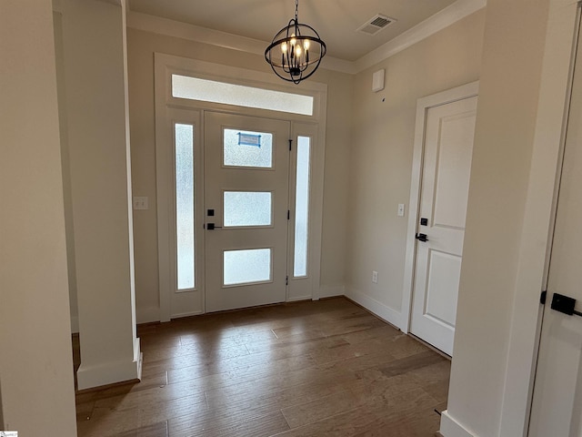 entrance foyer featuring light hardwood / wood-style floors, an inviting chandelier, and crown molding