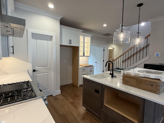 kitchen with white cabinets, sink, hanging light fixtures, dark hardwood / wood-style floors, and light stone countertops