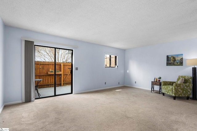 unfurnished room with light carpet, a textured ceiling, and plenty of natural light