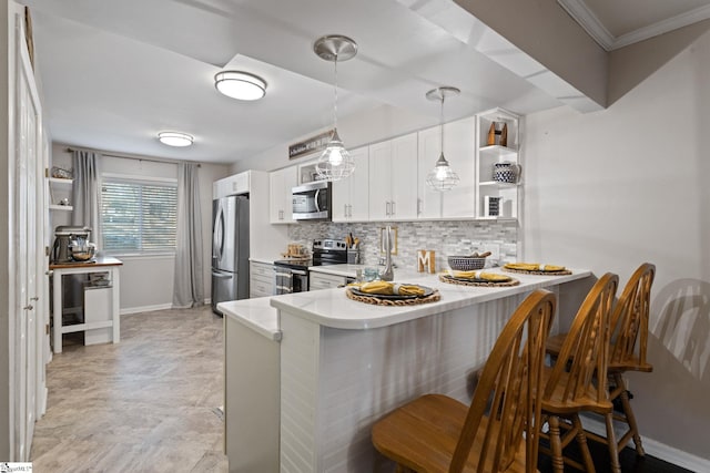 kitchen featuring kitchen peninsula, appliances with stainless steel finishes, a kitchen bar, backsplash, and white cabinets