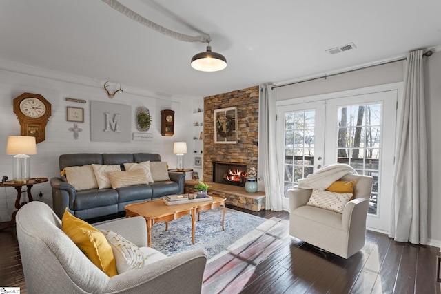 living room featuring dark hardwood / wood-style flooring, a fireplace, and french doors