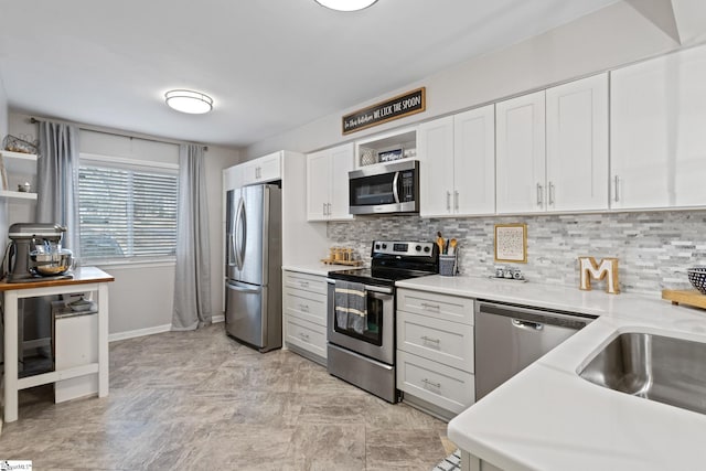 kitchen with white cabinets, sink, backsplash, and appliances with stainless steel finishes