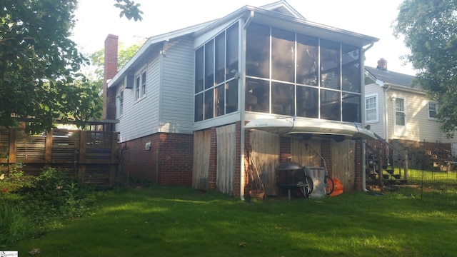 back of house featuring a yard and a sunroom