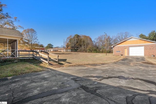 view of yard with a sunroom, an outbuilding, and a garage