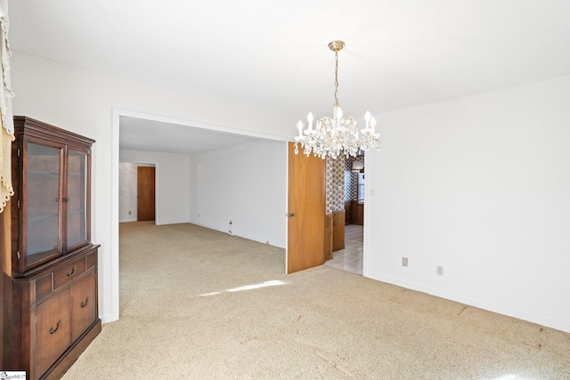 unfurnished dining area with light carpet and a notable chandelier