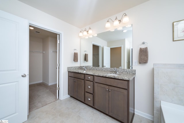 bathroom featuring tile patterned floors, vanity, and a bath