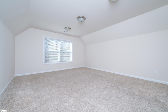 additional living space featuring carpet and lofted ceiling