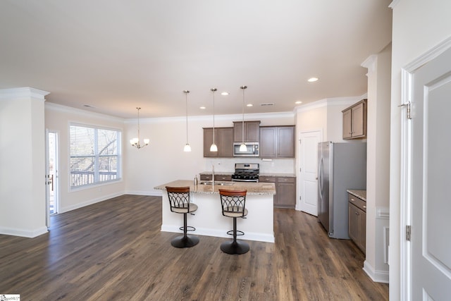 kitchen with a center island with sink, hanging light fixtures, dark hardwood / wood-style floors, and appliances with stainless steel finishes